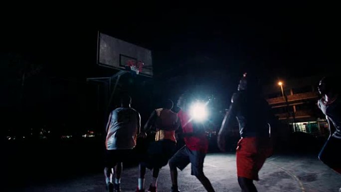 篮球运动员在夜间在法庭上比赛
