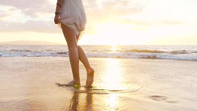 腿脚美丽的女孩赤脚走在湿沙热带岛屿海滩日落