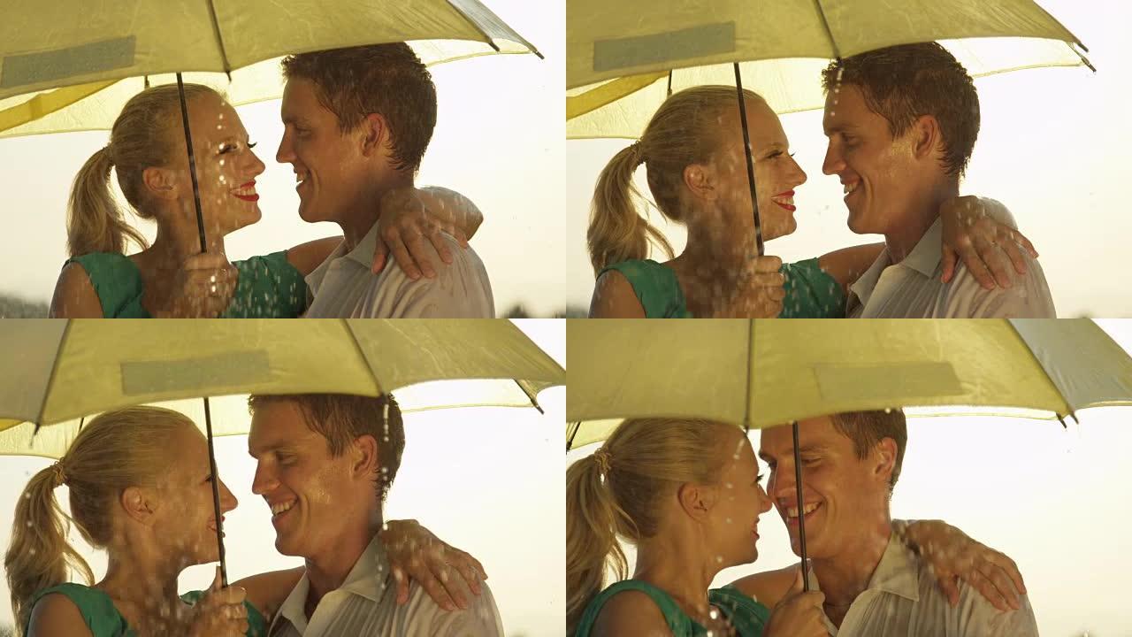 特写: 美丽的年轻夫妇在春雨中在伞下旋转。