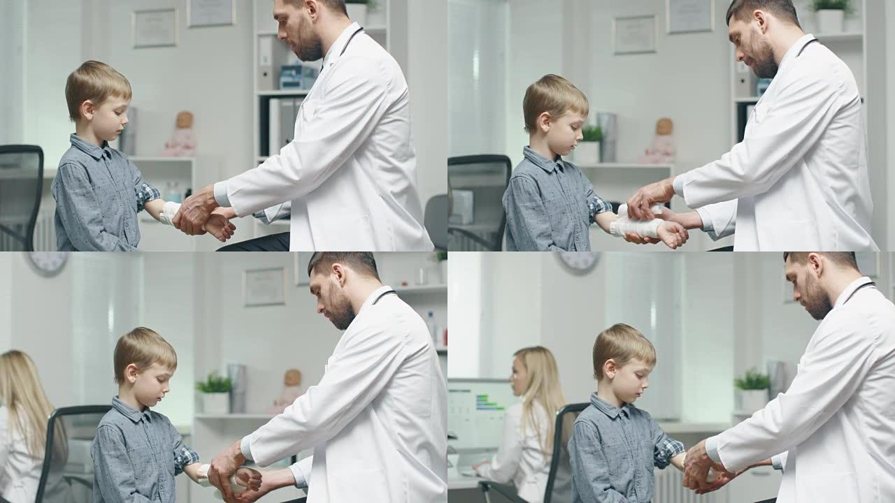 医生从小男孩的手上脱下绷带。
