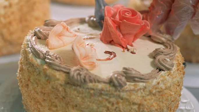 在蛋糕上放一朵奶油玫瑰。