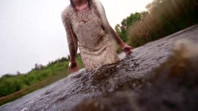 嬉皮士女孩站在湖里泼水