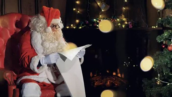 圣诞老人在圣诞树附近的椅子上阅读新年礼物清单。