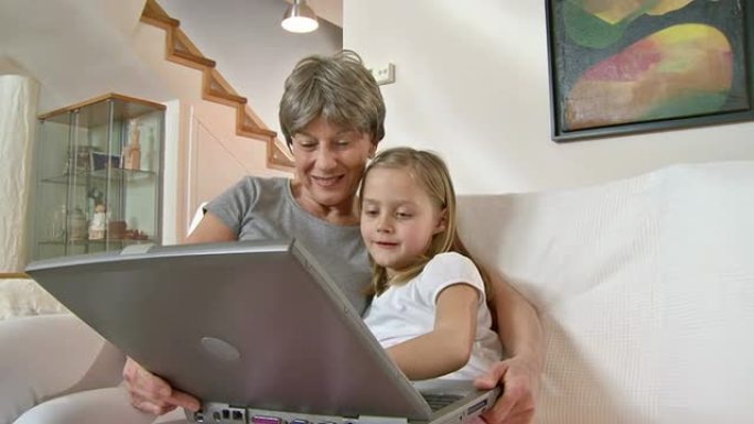 高清: 小女孩和奶奶一起使用笔记本电脑