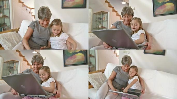 高清: 小女孩和奶奶一起使用笔记本电脑