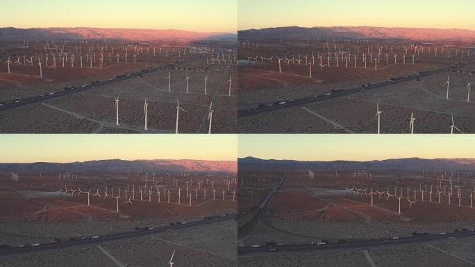 日落时沙漠中风电场和高速公路的鸟瞰图