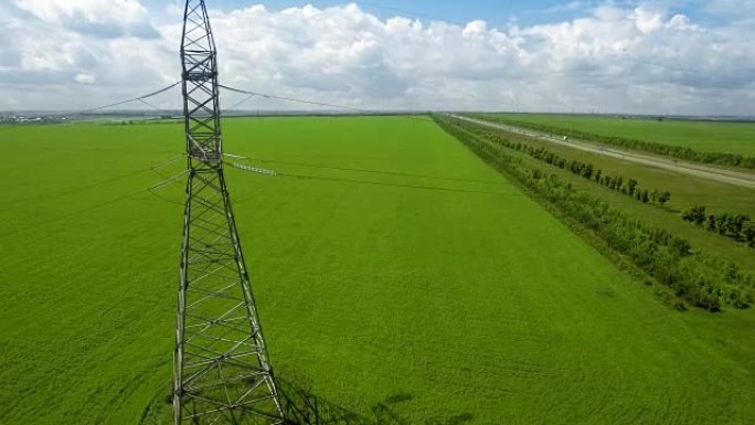 空中高压塔夏季灯光天空背景绿草向上提升飞