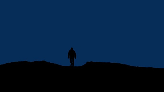 男人晚上走过山坡