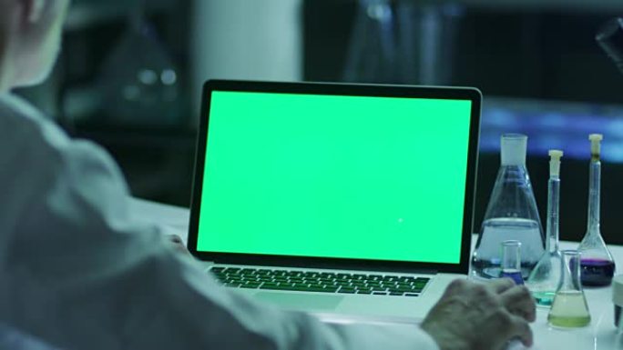 科学家正在实验室使用带有绿屏的笔记本电脑。非常适合使用模型。