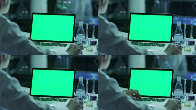 科学家正在实验室使用带有绿屏的笔记本电脑。非常适合使用模型。