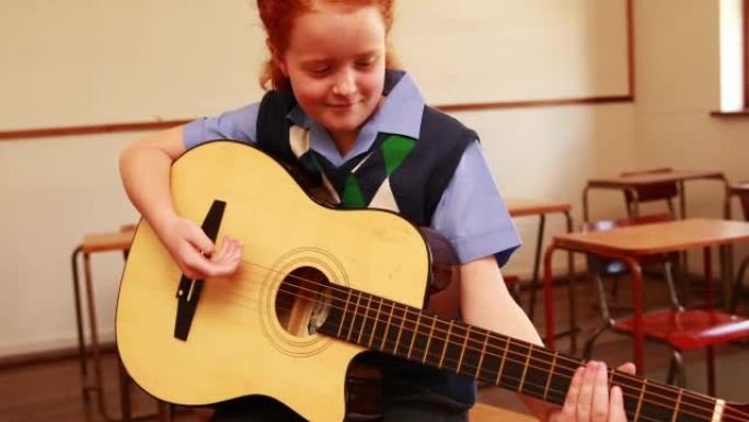 可爱的小学生在教室里弹吉他