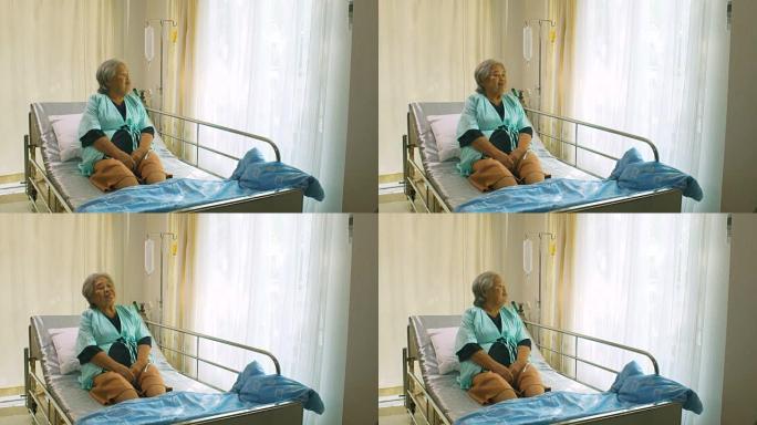 老年妇女坐在医院的病床上，悲伤的残疾人在病床上感到孤独。退休妇女独自在医疗诊所。