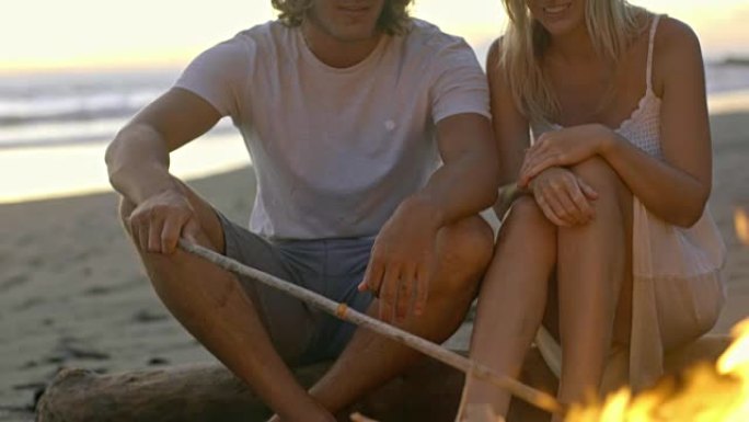 夫妇坐在海滩上着火