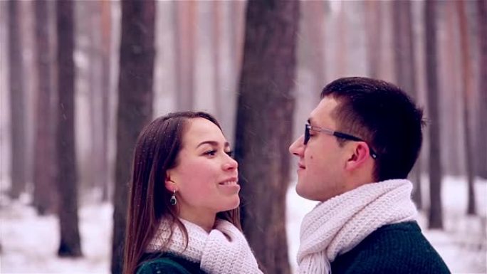 快乐的年轻夫妇在冬季森林里玩得开心