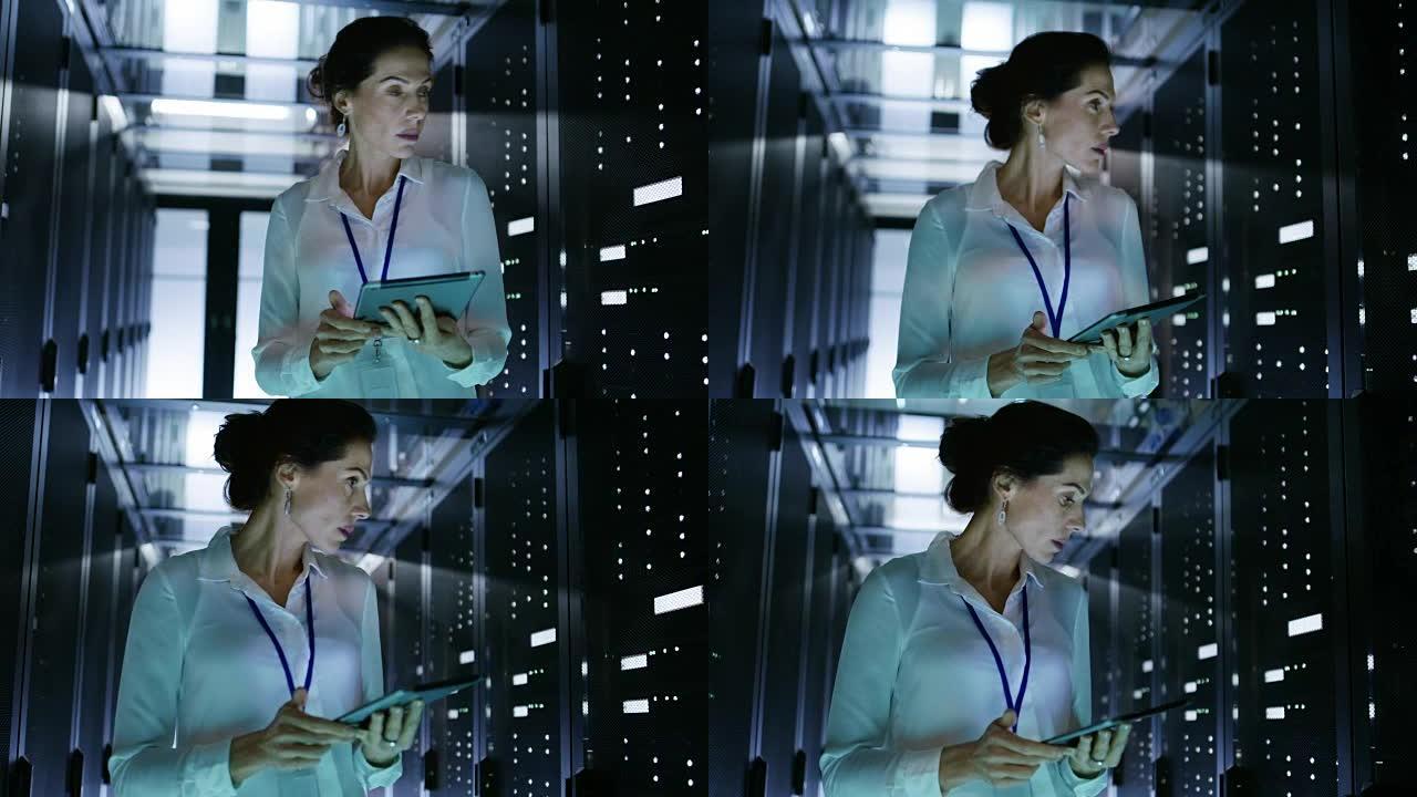 女性服务器技术人员带着成排的机架服务器走在数据中心走廊上。她在平板电脑上运行诊断程序