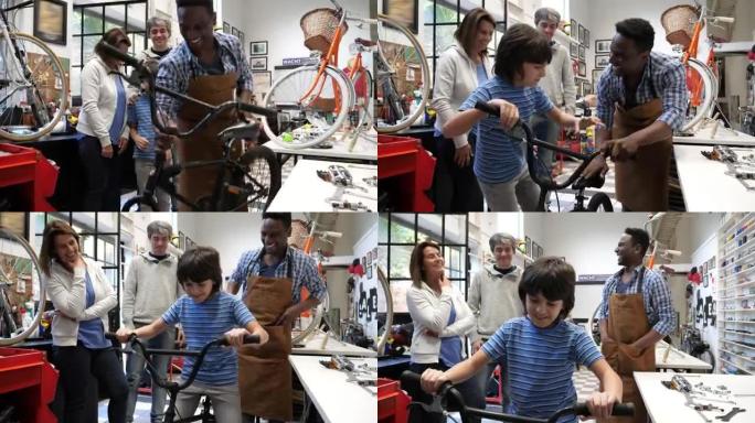 男孩和他的父母和友好的推销员在一家自行车商店里，让他尝试他的第一辆自行车，看上去很兴奋