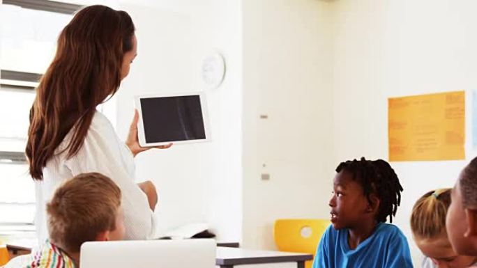 老师在教室里用数字平板电脑教学校的孩子