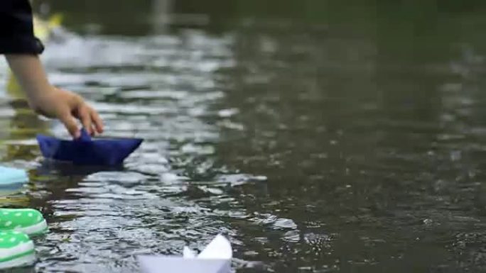 孩子们在水坑里玩纸船
