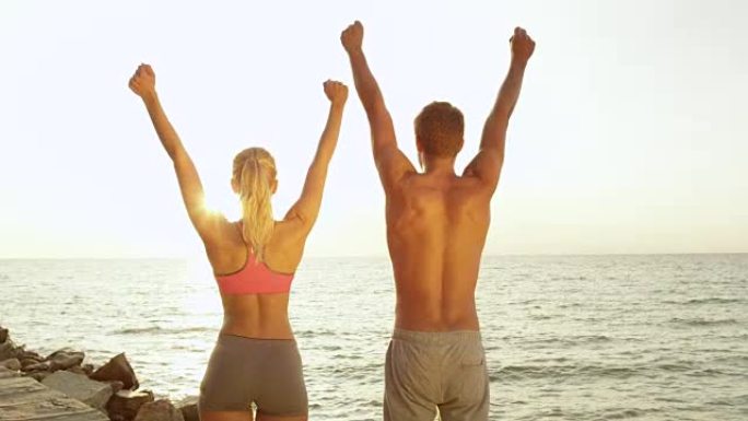 特写，太阳耀斑: 欢乐的年轻夫妇在奔跑后伸出双臂