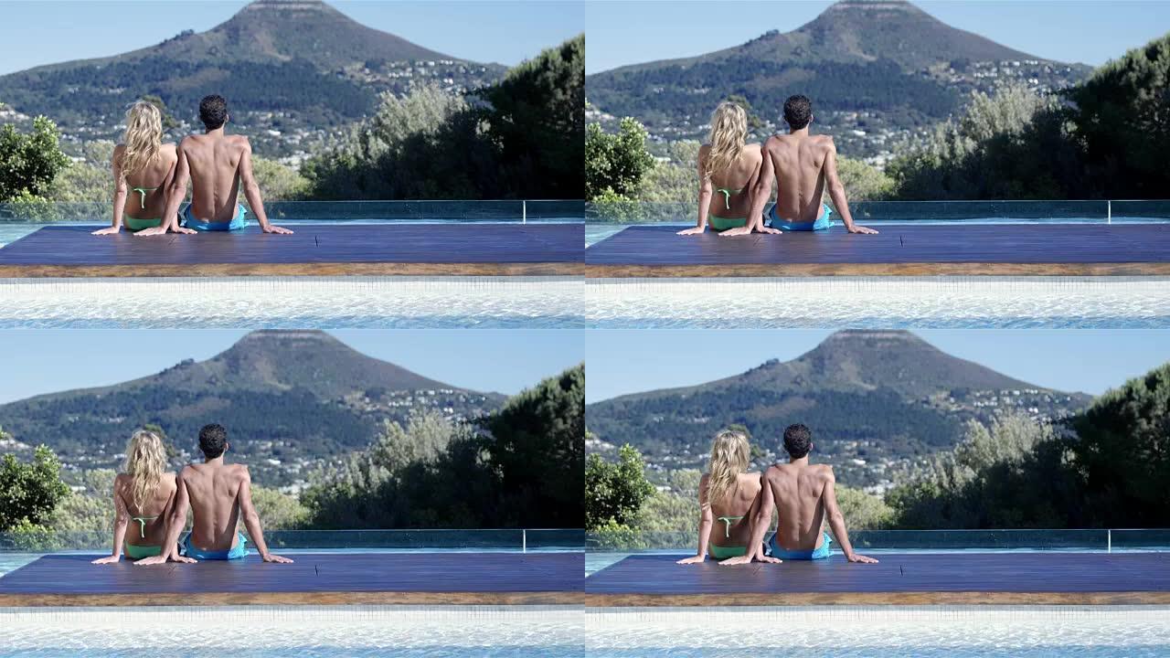 夫妇双脚坐在游泳池里