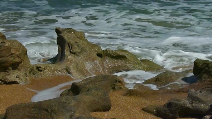 巨石上的冲浪特写大海边浪花海岛拍打石头礁