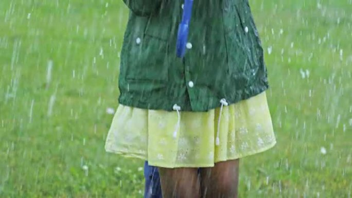 女孩在雨中跳跃和大笑
