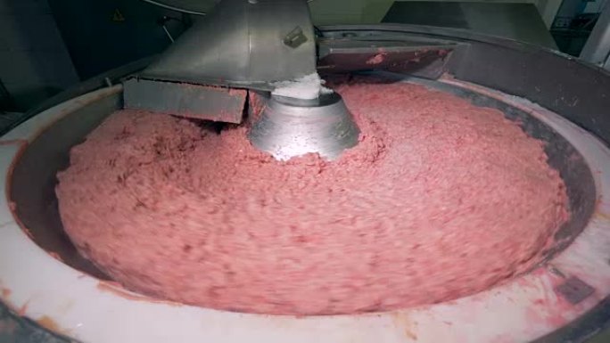 一堆肉在搅拌工厂的机器中旋转