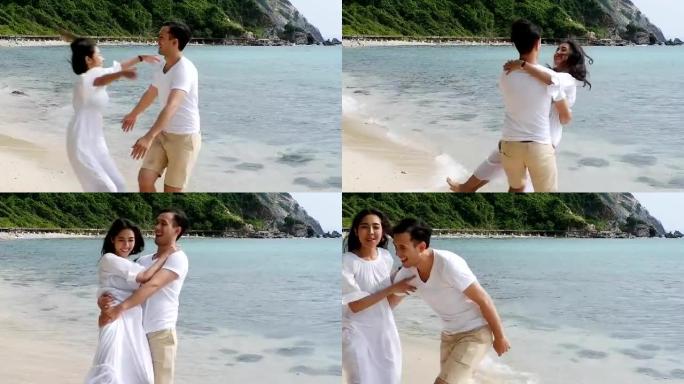年轻夫妇在海滩上拥抱在一起。有吸引力的健康夫妇享受一起在海滩上散步的时光。