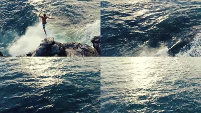 年轻人从海洋悬崖跳下日落的4k航拍。