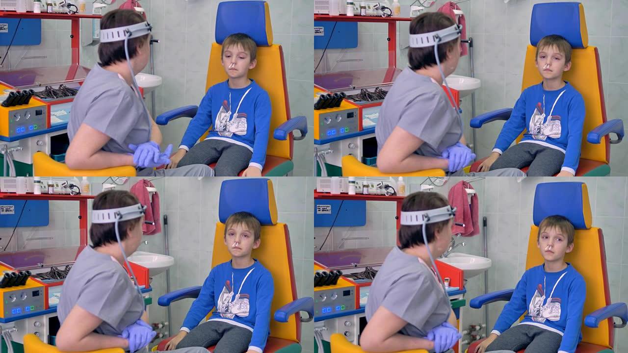 一个男孩坐在医生办公室，鼻子上有棉签。