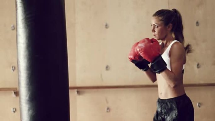 美丽的年轻女运动员锻炼自我防卫与拳击手套
