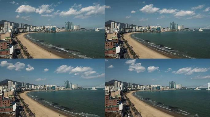韩国釜山市海云台海滩。汽车交通、云、行走的人和波浪的时间流逝