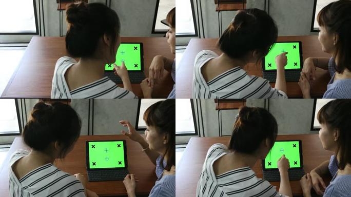 两名亚洲妇女使用平板电脑绿屏