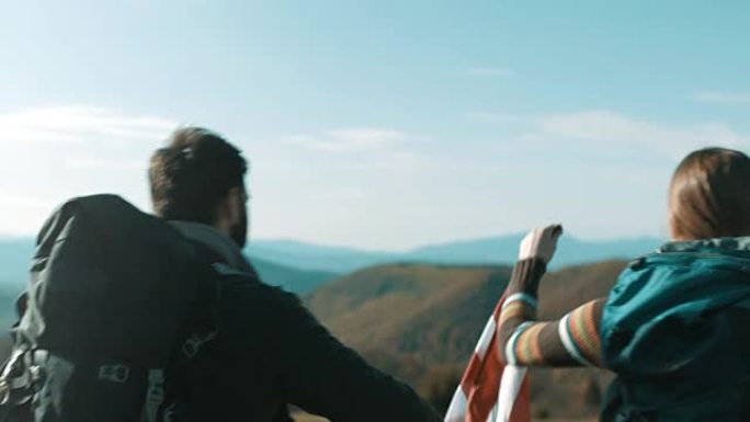 几个徒步旅行者在山顶的空中升起美国国旗