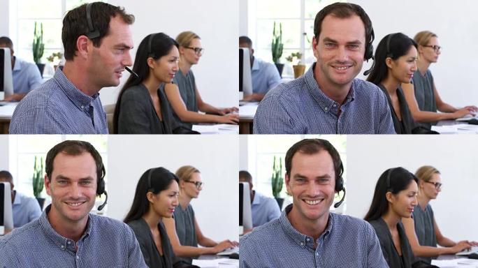 戴着耳机的白人在开放式办公室对着镜头微笑