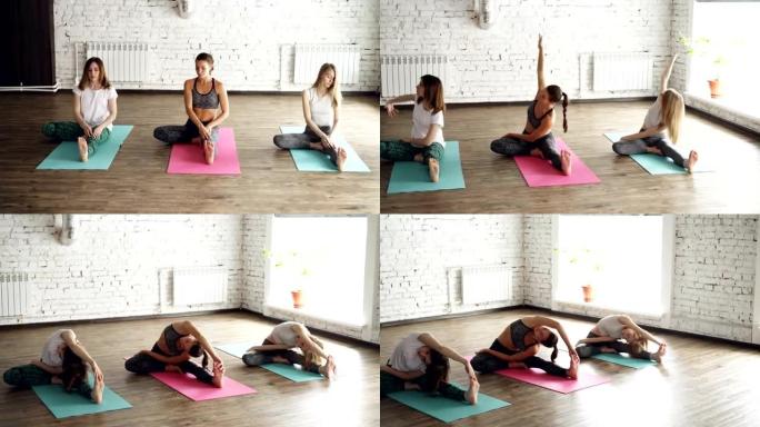 年轻灵活的女性坐在尼斯光工作室的瑜伽垫上做各种伸展运动。他们弯曲的头或胸部到膝盖集中在呼吸。
