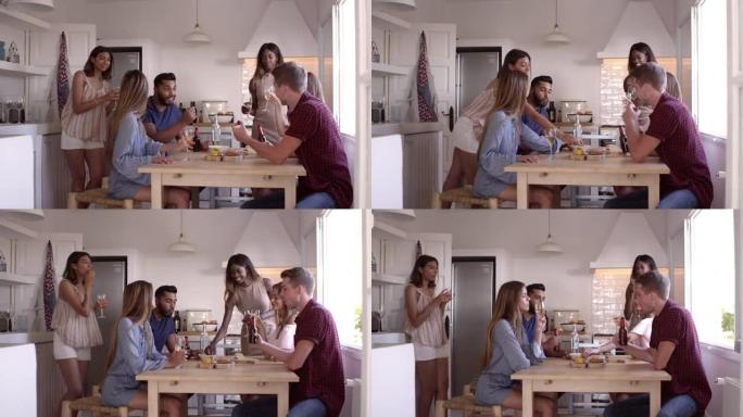 年轻的成年朋友在厨房里喝酒和吃零食，在R3D上拍摄