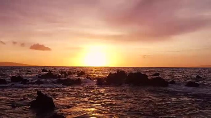 慢动作中惊人的戏剧性日落景色。空中射击在夏威夷的海洋上空低空飞行