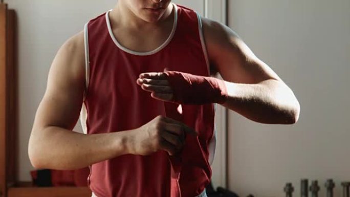 年轻的拳击手手上缠着红色绷带