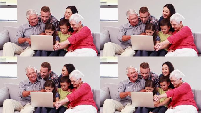 使用笔记本电脑微笑的多代家庭