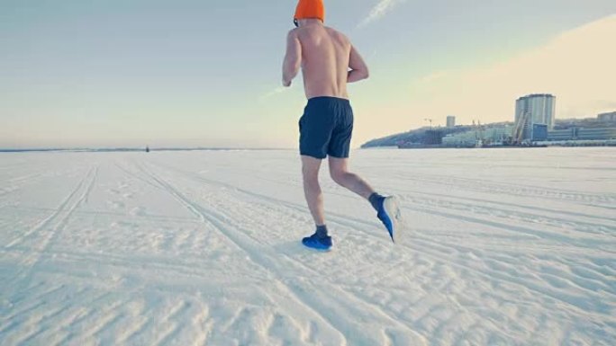 一个穿着跑步的男人在雪地上慢跑。