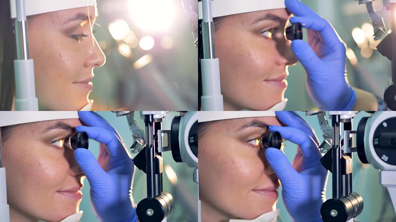 医生手中的一只眼睛被用来检查年轻女子的眼睛的特写