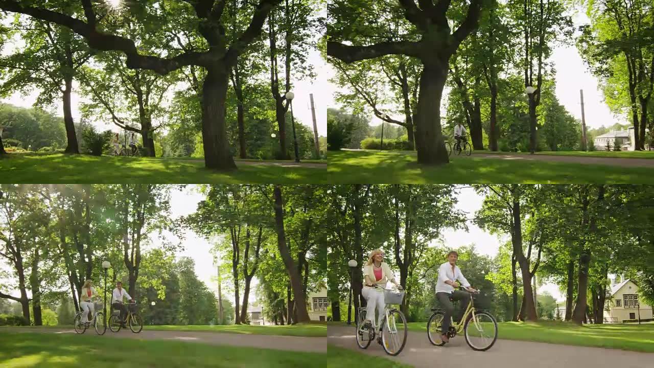 快乐的成年夫妇在公园骑自行车。