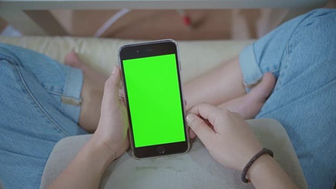 使用智能手机的女性高角度视角，绿屏
