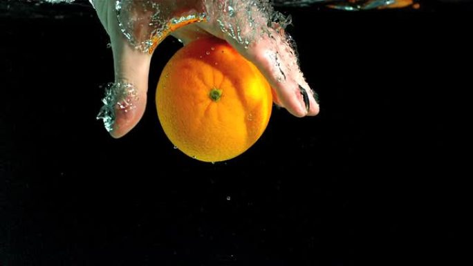 手从水中取出橙子