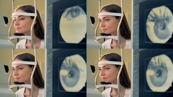 一名妇女将头放在视网膜摄像头的下巴上。