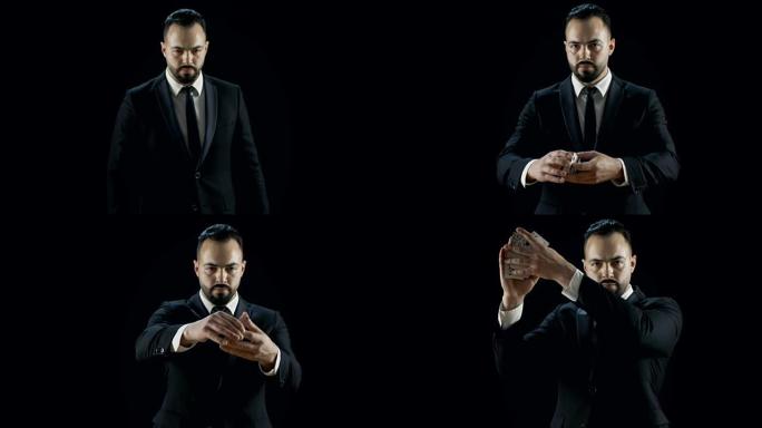 身穿黑色西装的魔术师走进灯光确实可以将纸牌从一只手扔向另一只手。
