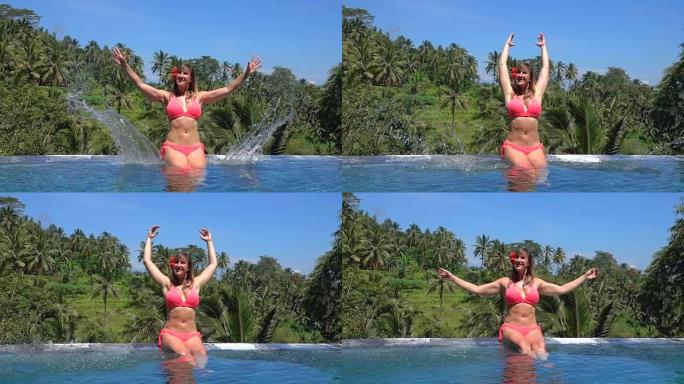 特写欢快的女孩在热带岛屿的无边泳池里溅水滴
