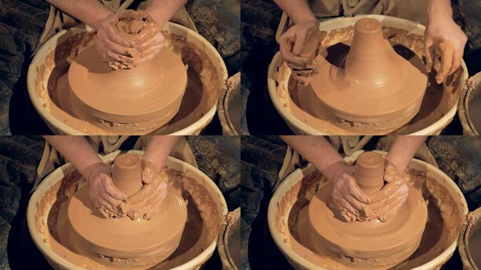 陶工用双手将粘土扔进一个高大的花瓶中。