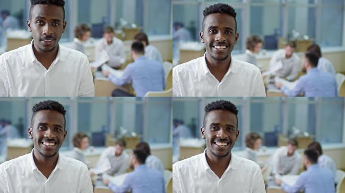 年轻的非洲商人使用平板电脑并在相机前微笑